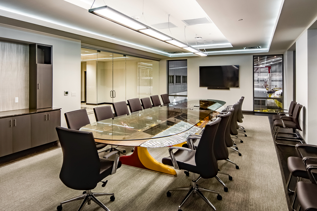 A bi-plane wing conference table and aviation details define this executive board room where modern meets industrial.