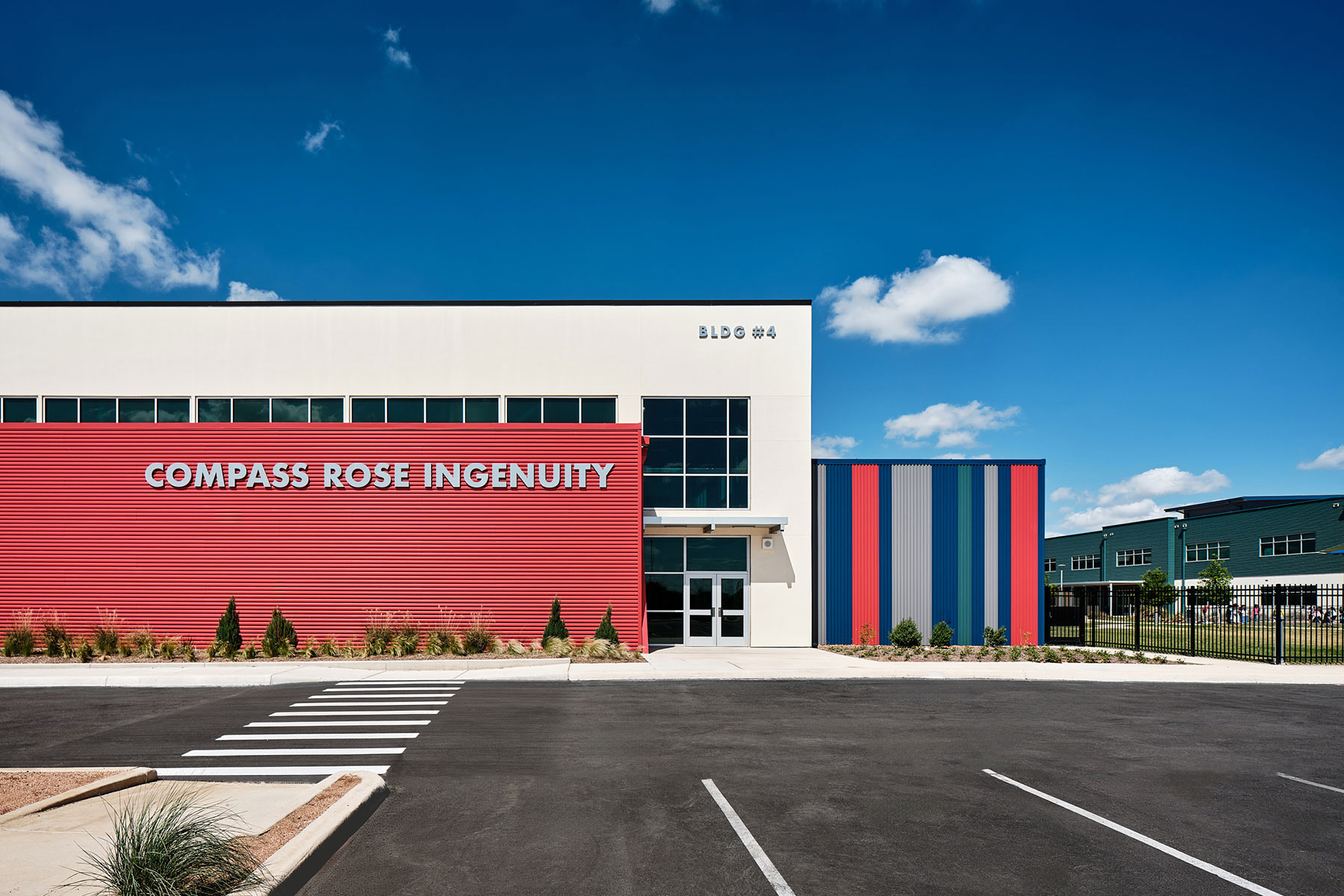 The metal panels on the exterior of the high school feature a repeated green stripe, which recalls the same green used on the elementary school (right).