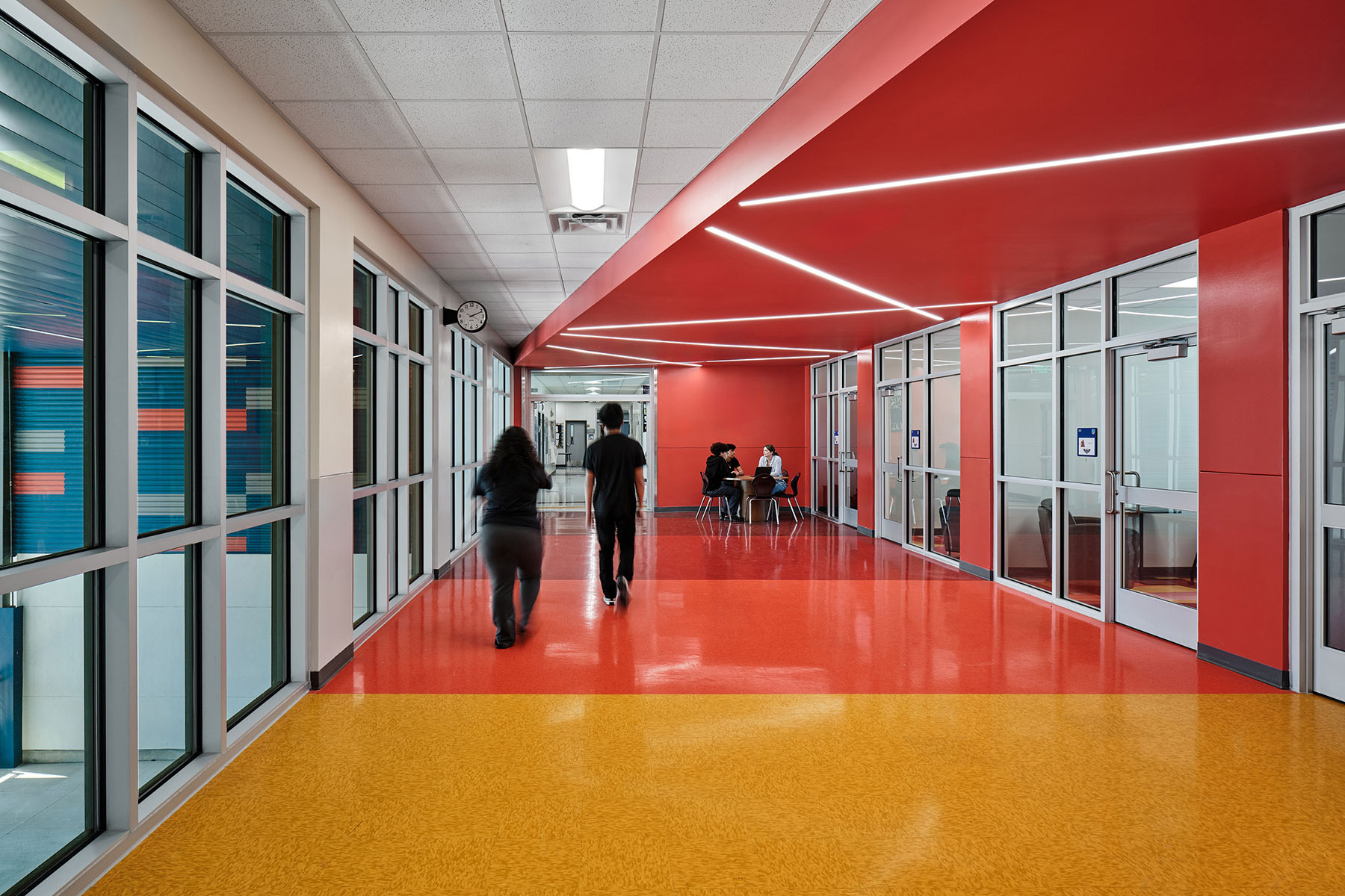 The corridor connecting the middle and high schools is home to the college center and features warm color gradients.
