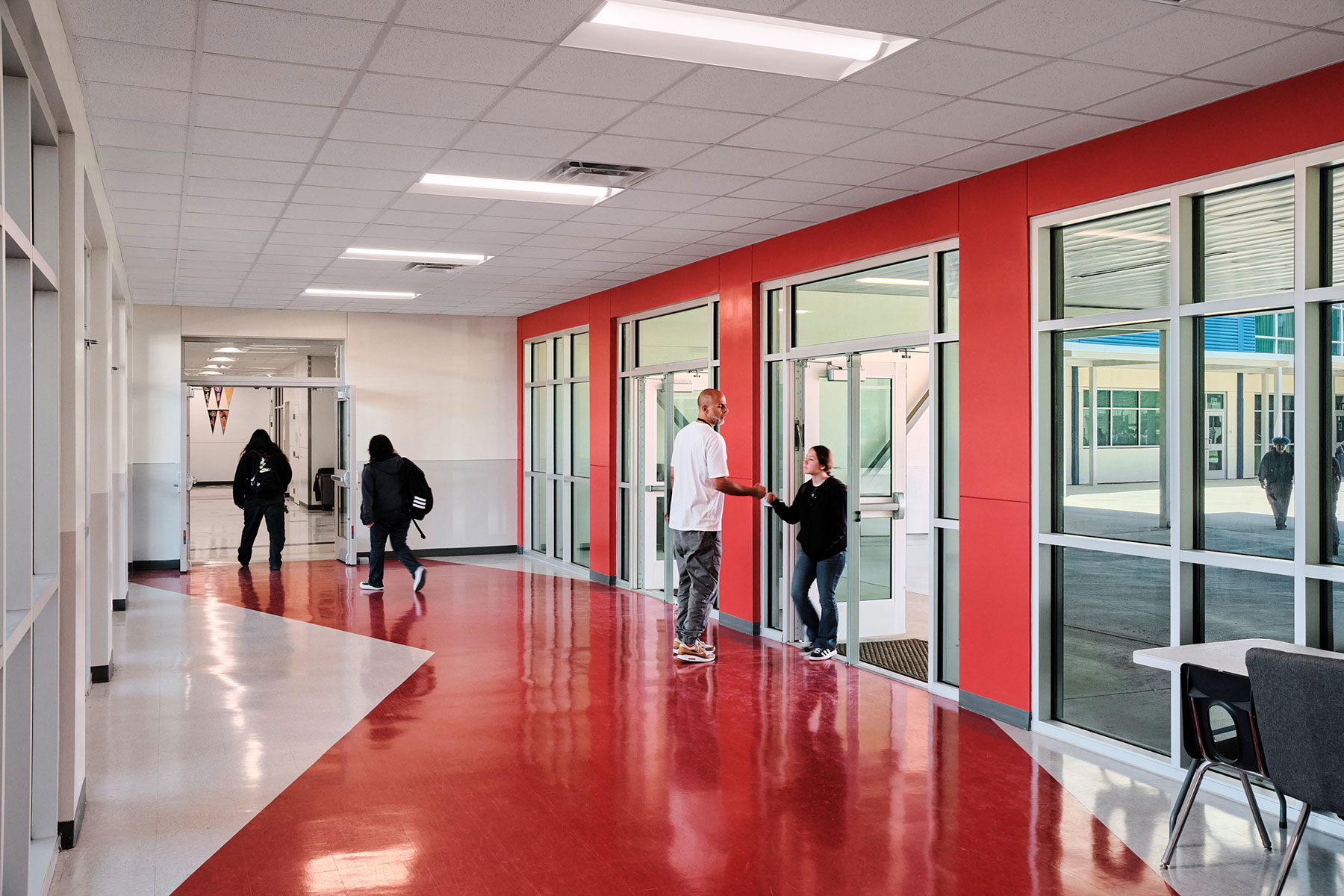 The corridor between the high school and middle school uses color to point students toward the adjacent makerspace. It also overlooks the central courtyard between the schools.